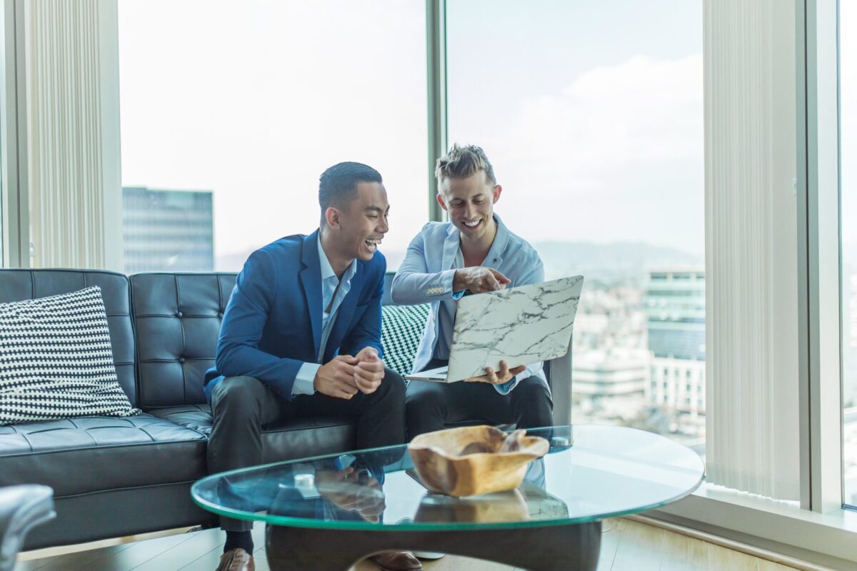two men in suit sitting on sofa