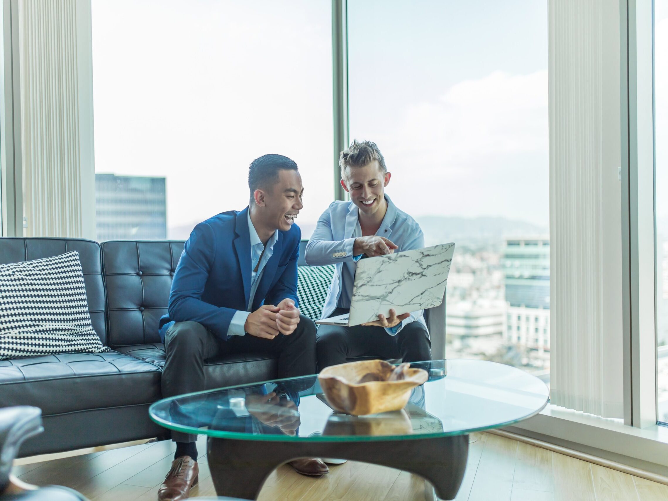 two men in suit sitting on sofa