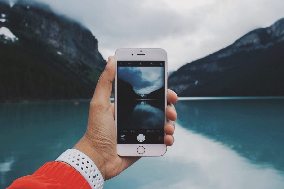 person taking photo of lake
