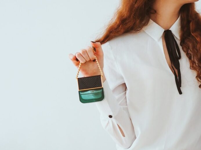 woman in white dress shirt and black skirt holding green and white plastic bottle