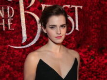 Emma Watson, who plays Belle, in front of rose wall