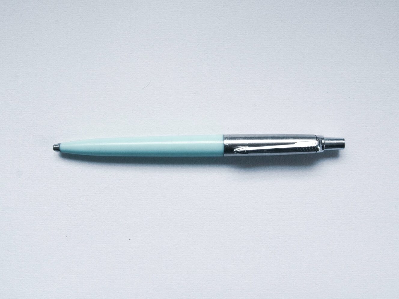 green and silver click pen
