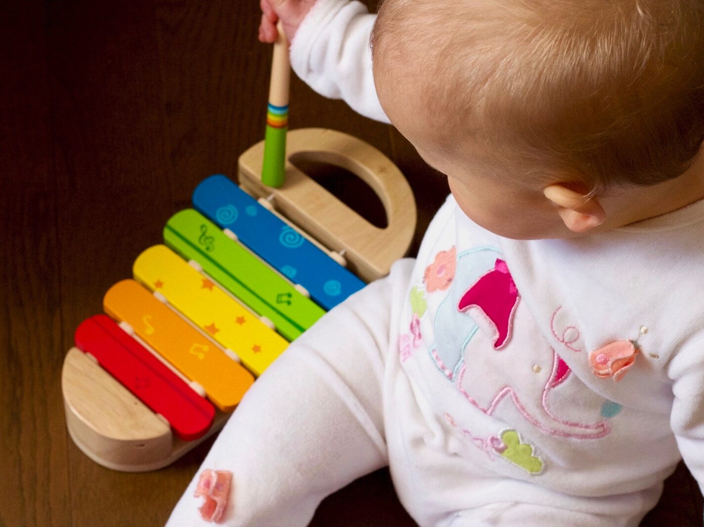 baby playing multicolored xylophone toy