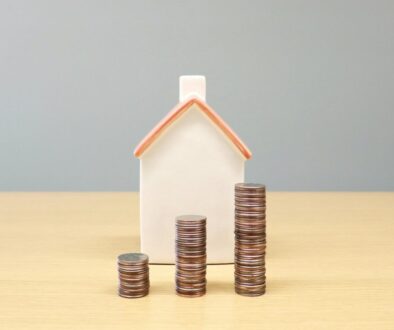 Zdroj: a house and stacks of coins on a table