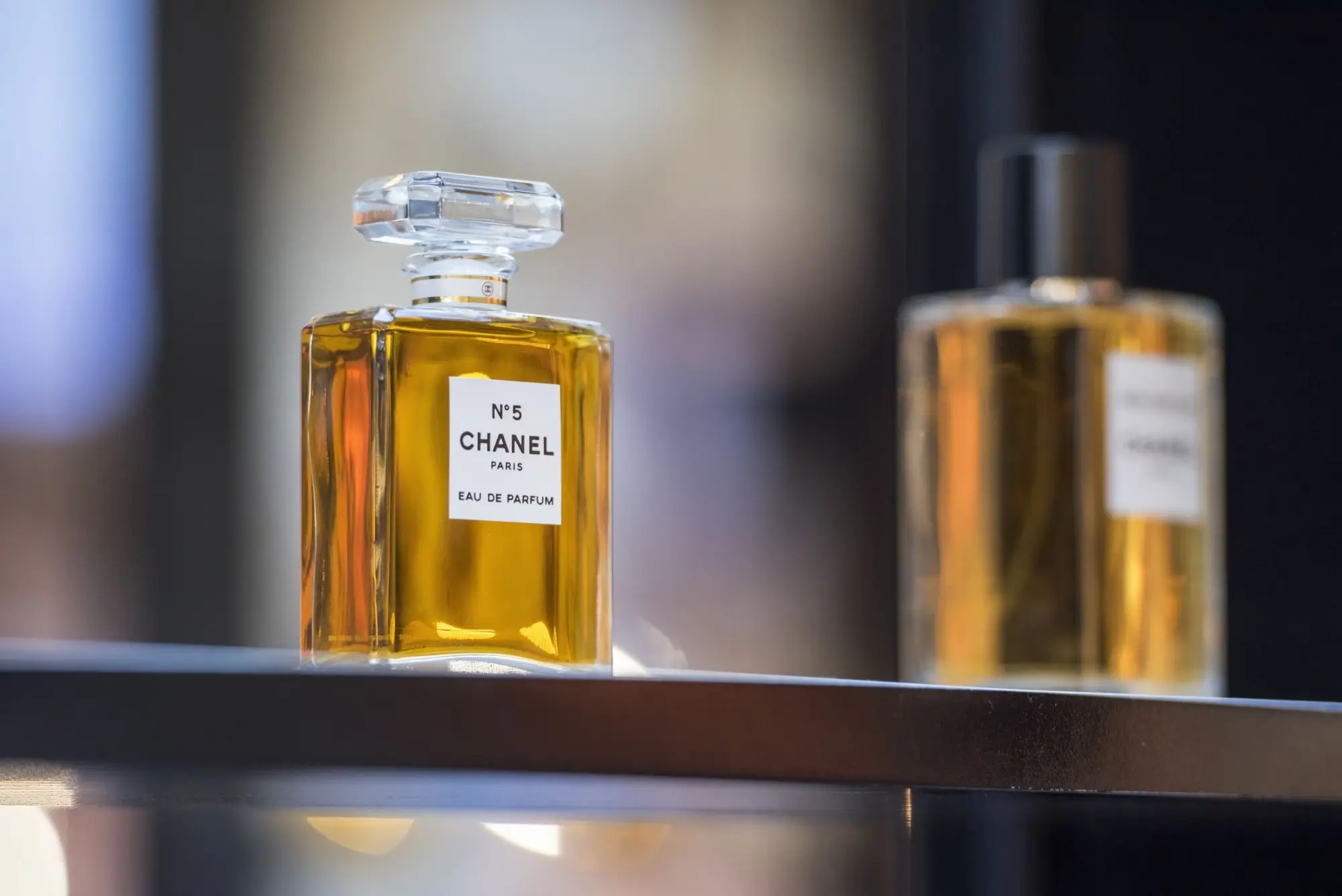 Flakon parfému Chanel No5 na skleněné polici v Paříži