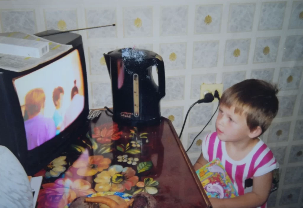 Chlapec sleduje televizi u stolu v kuchyni