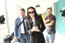Agáta Hanychová odchází od soudu, novináři v pozadí