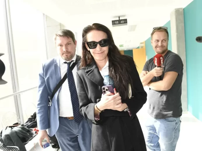 Agáta Hanychová odchází od soudu, novináři v pozadí