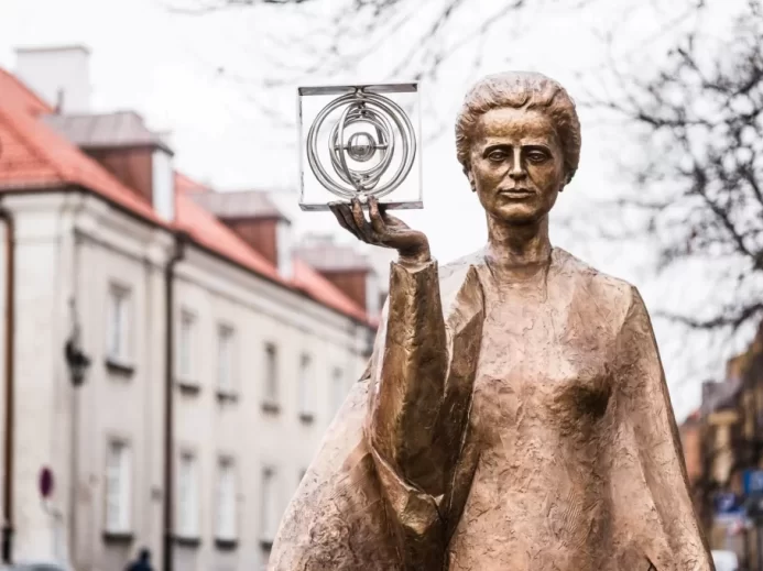 Socha Marie Sklodowské-Curie od polského sochaře Bronislawa Krzysztofa. Vědkyně, nositelka Nobelovy ceny, drží v ruce grafický symbol polonia