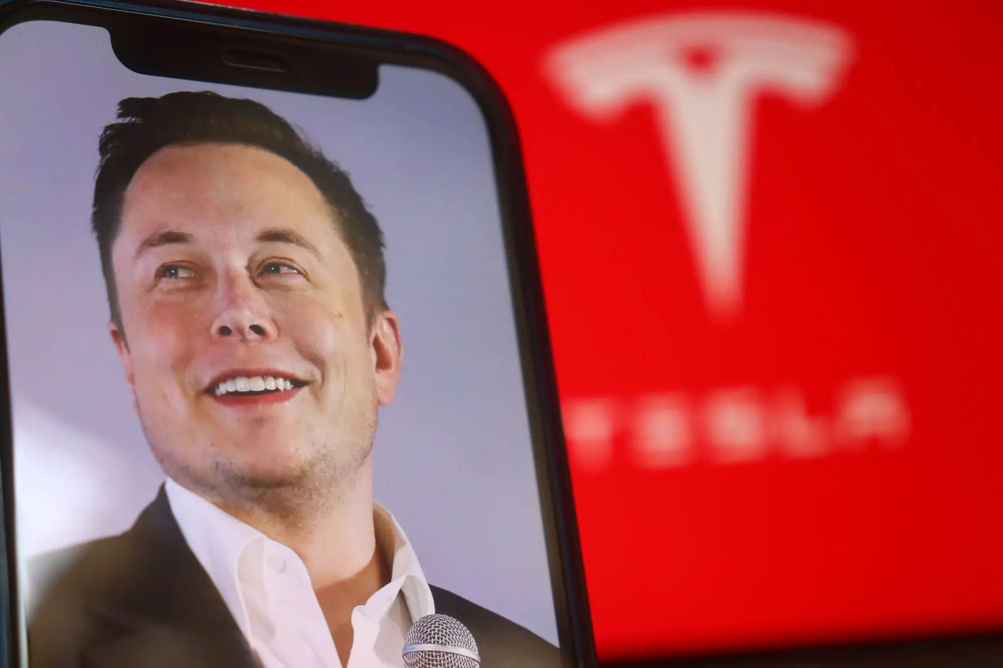 - VIPshow Elon Musk na pozadí symoblu své Tesly.