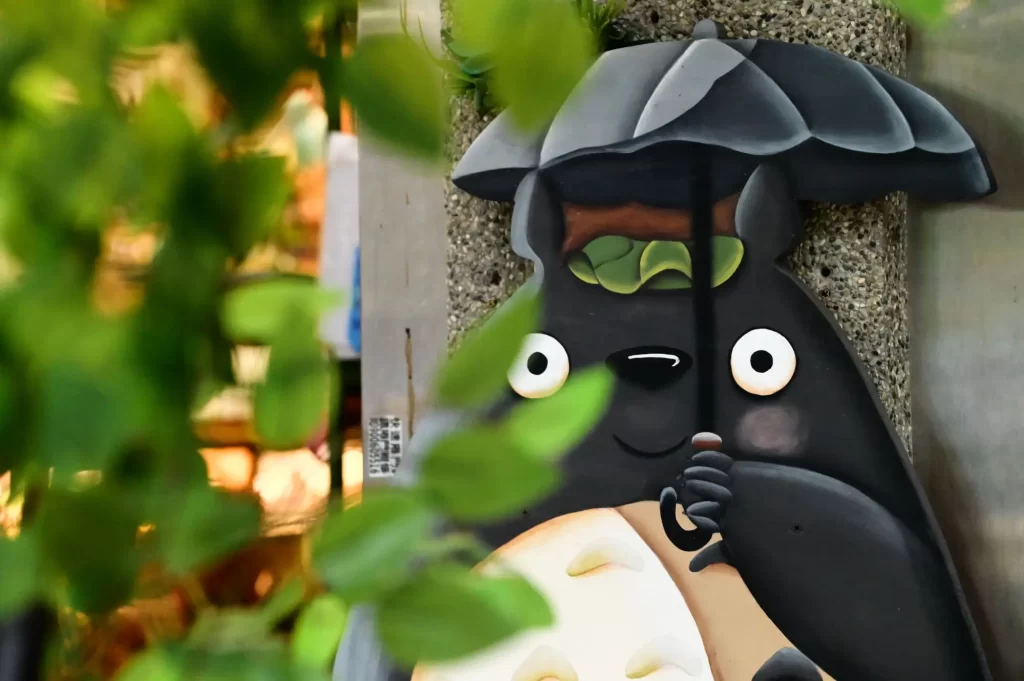 Detailní záběr na Totora ze Studia Ghibli, který drží deštník.