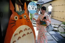 Japonská dívka v tradičním oblečení stojí u postavičky Totora.