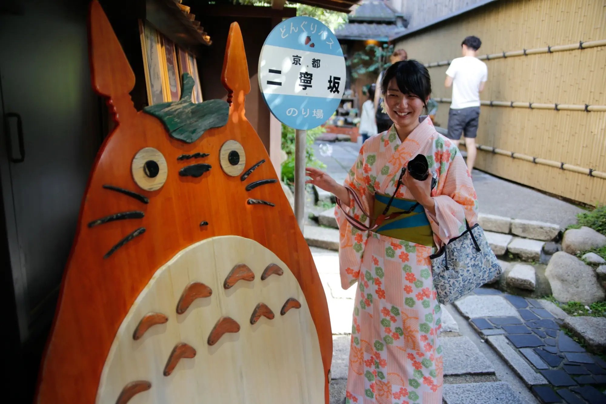 Japonská dívka v tradičním oblečení stojí u postavičky Totora.