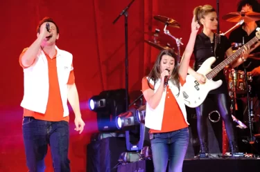 Živé vystoupení hvězd ze seriálu Glee. V popředí zpívají Cory Monteith a Lea Michele