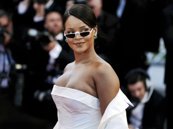 Rihanna v bílých slavnostních šatech a slunečních brýlích