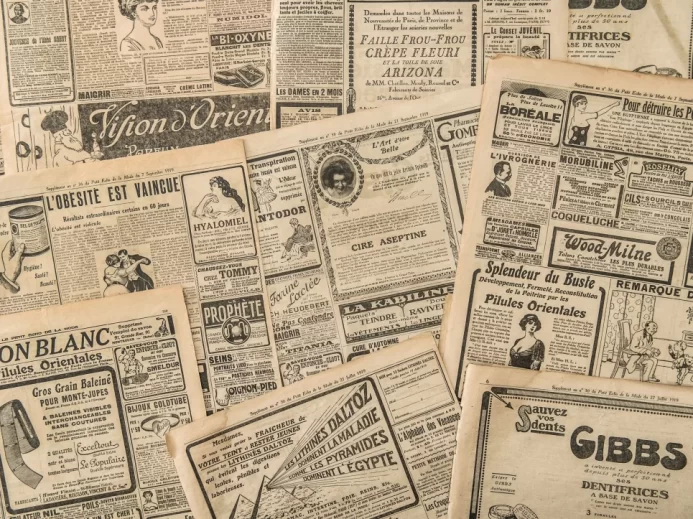 Stránky novin se starožitnou reklamou. Vintage módní časopis pro ženy