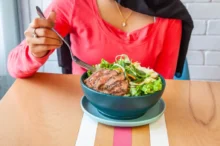 žena v červeném jí Caesar salát