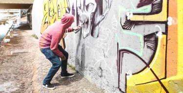 Muž sprejuje na zeď