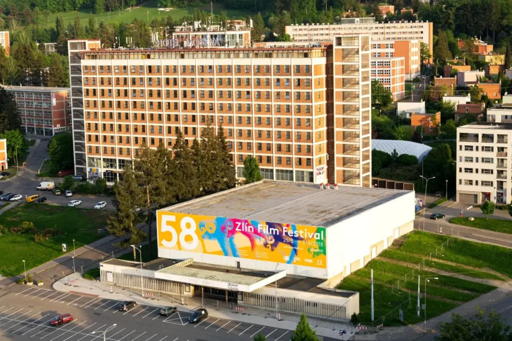 Pohled na zlínské Velké kino s poutačem Zlín Film Festivalu a ikonickým hotelem Moskva