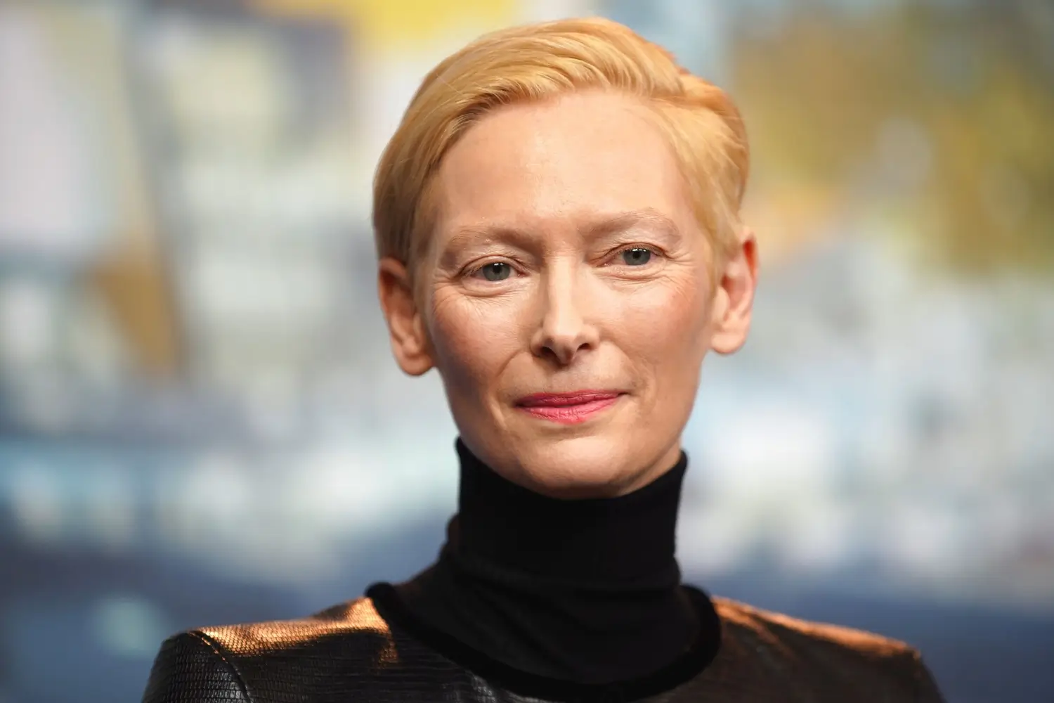 Tildy Swinton v černém roláku a přirozeném líčení, herečka hledí klidně do objektivu během tiskové konference