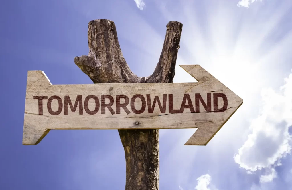 Dřevěná směrovka s nápisem Tomorrowland 