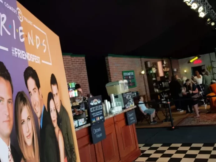 Návštěvnický prostor tematicky laděný do stylu kavárny Central Perk se stojanem s oficiálním plakátem seriálu Friends