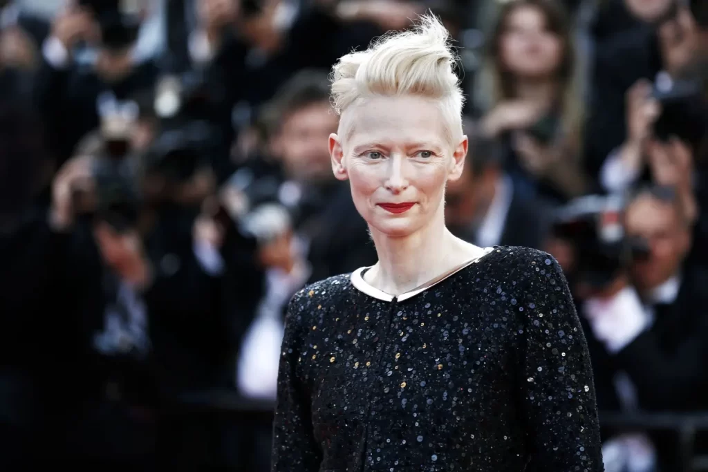Tilda Swinton na filmovém festivalu s výrazným blonďatým účesem a černými flitrovými šaty