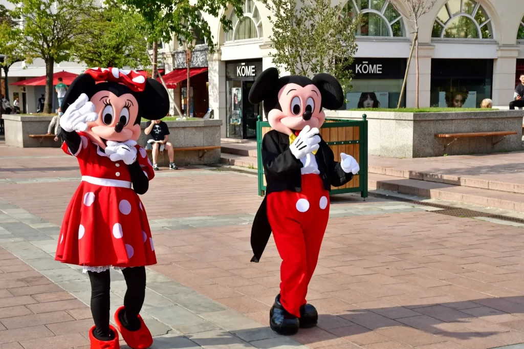 Dvě postavy v kostýmech – slavní animovaní hrdinové Mickey Mouse a Minnie Mouse.