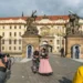 Kameraman, komparzisté a ženy v historických kostýmech před vstupem do Pražského hradu