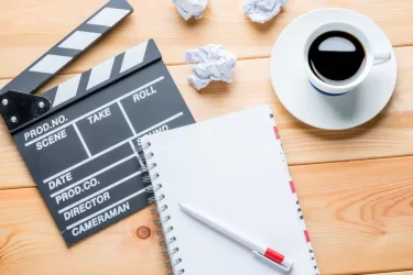 Sešit, filmová klapka a káva - ilustrační obrázek pro psaní scénáře