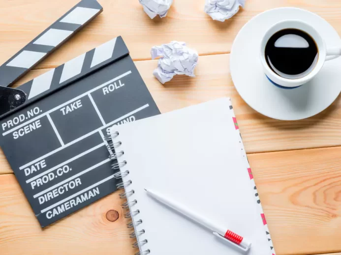 Sešit, filmová klapka a káva - ilustrační obrázek pro psaní scénáře