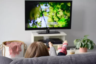 žena koukající se na televizi