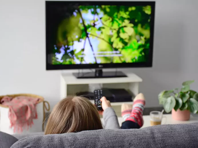 žena koukající se na televizi