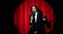 Muž stand-up comedy červená opona