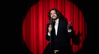 Muž stand-up comedy červená opona