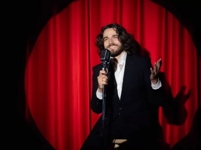 Muž stand-up comedy červená opona