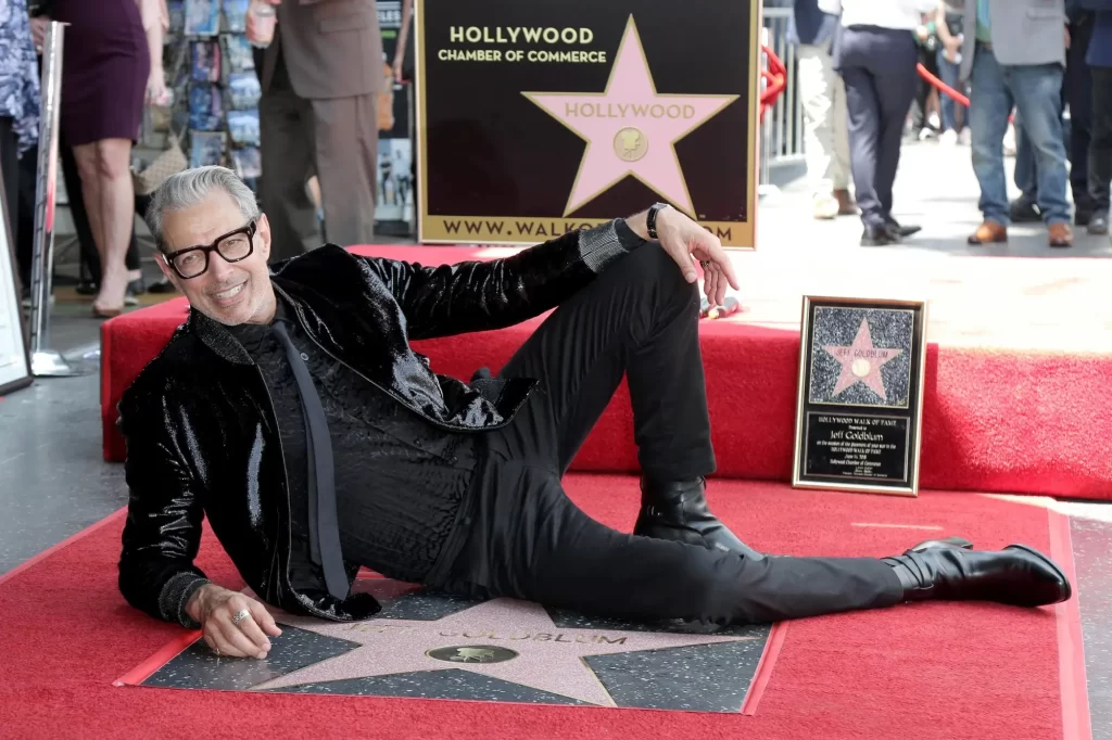 Jeff Goldblum leží na chodníku u své hvězdy. 