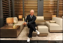 Georgio Armani pózuje v obývacím pokoji v obleku