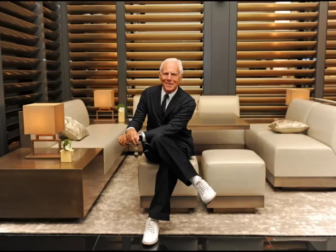 Georgio Armani pózuje v obývacím pokoji v obleku