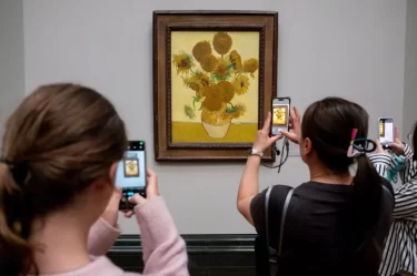Návštěvníci muzea pořizují fotografii obrazu Slunečnice (Vincent van Gogh)