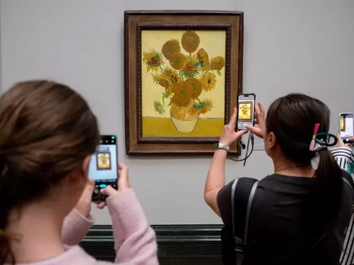 Návštěvníci muzea pořizují fotografii obrazu Slunečnice (Vincent van Gogh)