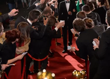 fanoušci okolo červeného koberce při příchodu celebrity