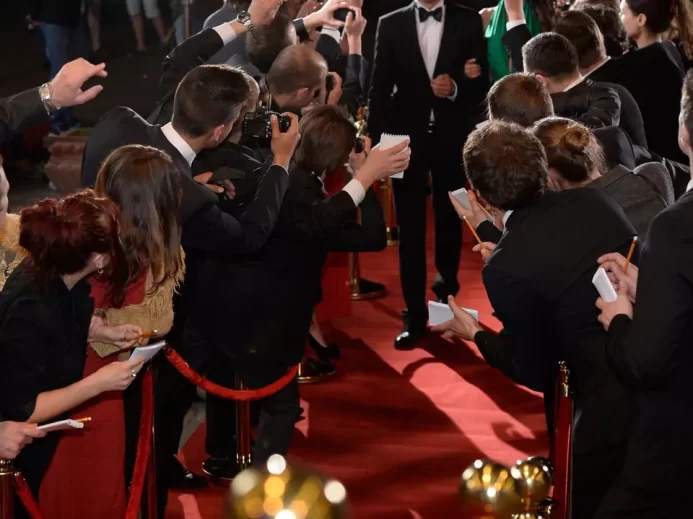 fanoušci okolo červeného koberce při příchodu celebrity