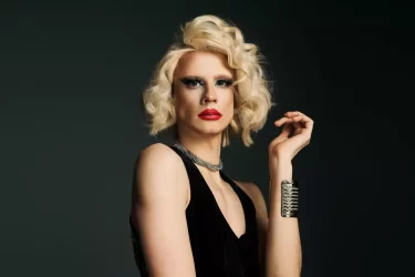 Drag queen s blonďatými vlasy a výrazným makeupem