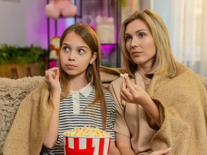 I dospělí si na pohádkách najdou to své Matka s dcerou společně sledují televizi s popcornem a přikryté dekou