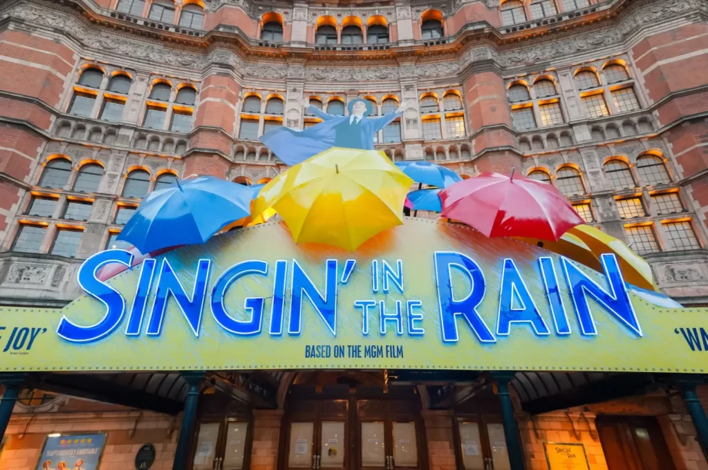 Shutterstock_129595808 - VIPshow Divadelní budova ozdobená barevnými deštníky a neonovým nápisem Singin’ in the Rain