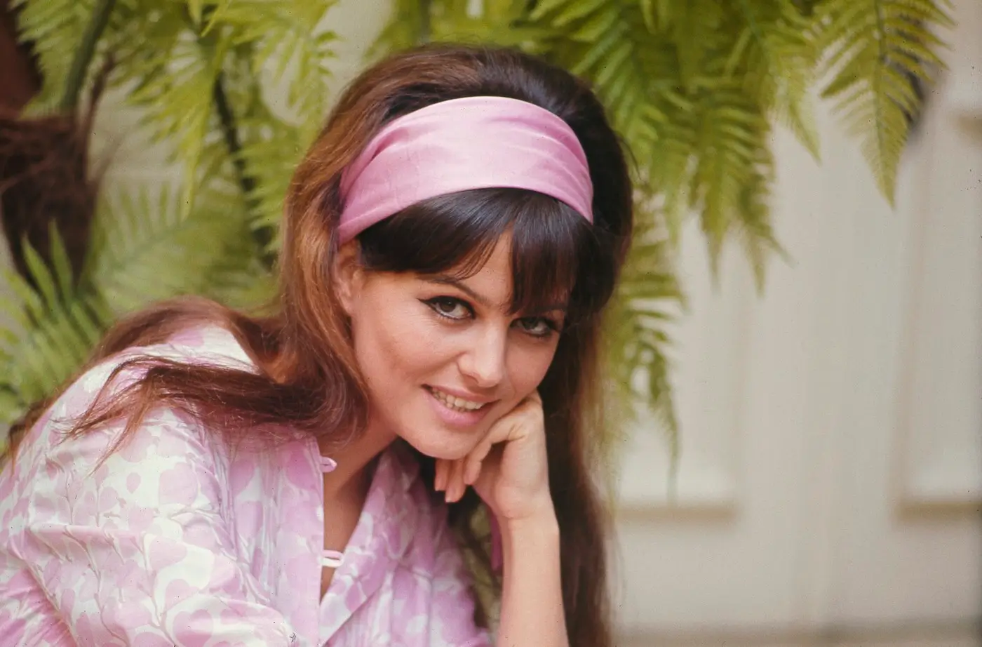 Usměvavá Claudia Cardinale s růžovou čelenkou a jemným líčením