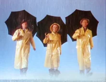 Hlavní herci muzikálu Zpívání v dešti v žlutých pláštěnkách tančí synchronizovaně s černými deštníky, během slavné závěrečné scény na zaplaveném jevišti
