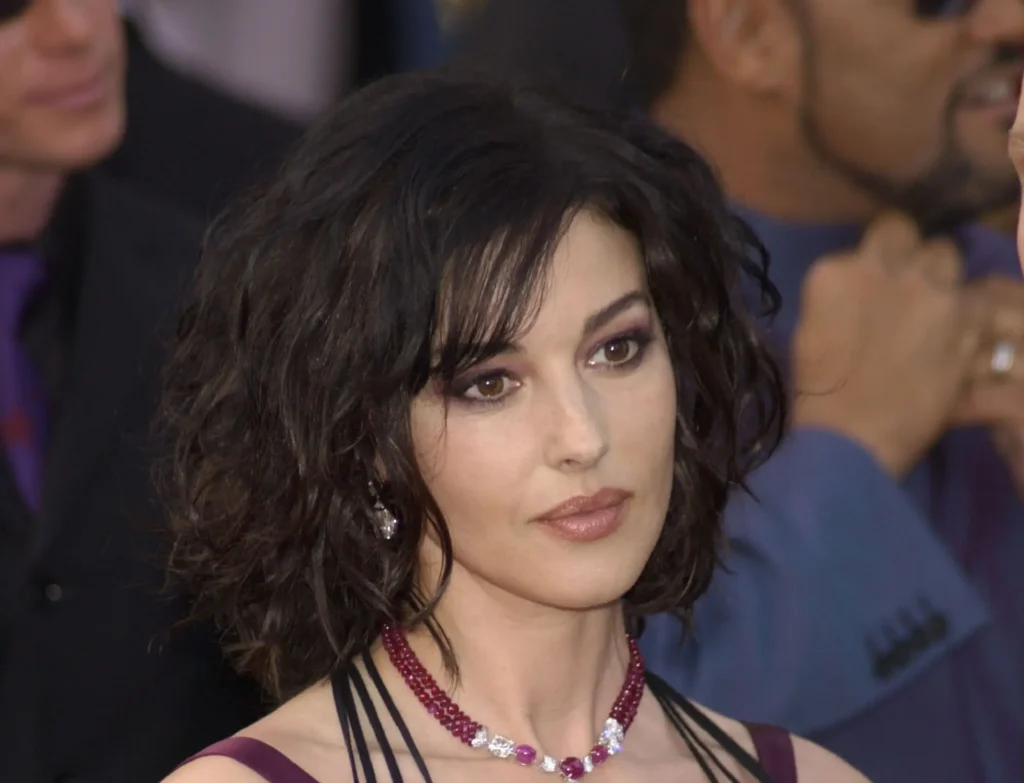 Monica Bellucci na červeném koberci v roce 2003 s krátkým vlnitým účesem a elegantním šperkem