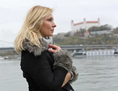 Adriana Tarábková stojící u Dunaje s pohledem na Bratislavský hrad